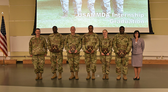 Interns from the USAMMDA's Program Management–Acquisition Internship Program are presented with awards during the graduation ceremony