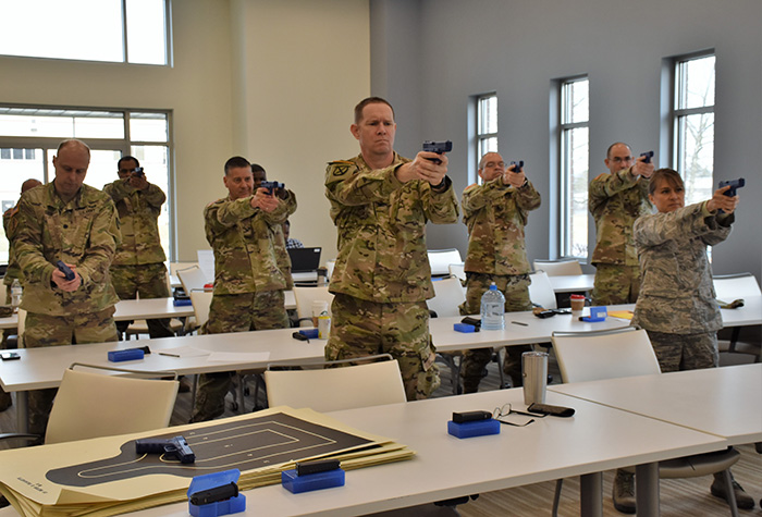 Military officers with the USAMMDA practice their shooting stance