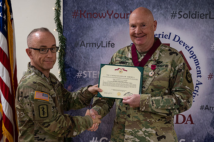 Col. Andy Nuce, left, presents the Legion of Merit award