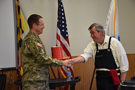 Lt. Col. David Saunders, USAMMDA acting commander, presents the coveted Can O' Beans trophy