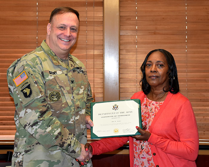 Col. William E. Geesey presents Teri Glass with a Certificate of Retirement from the Department of the Army